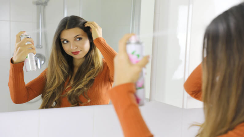 woman applying dry shampoo